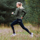 Vrouw hardloopt buiten tussen bomen