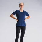 Vrouw in blauw sporttop en zwarte hardlooptight, lichtgrijze achtergrond