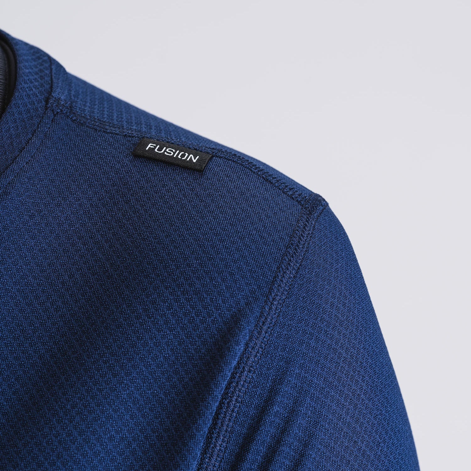 Blauw sporttop met Fusion-label, lichtgrijze achtergrond