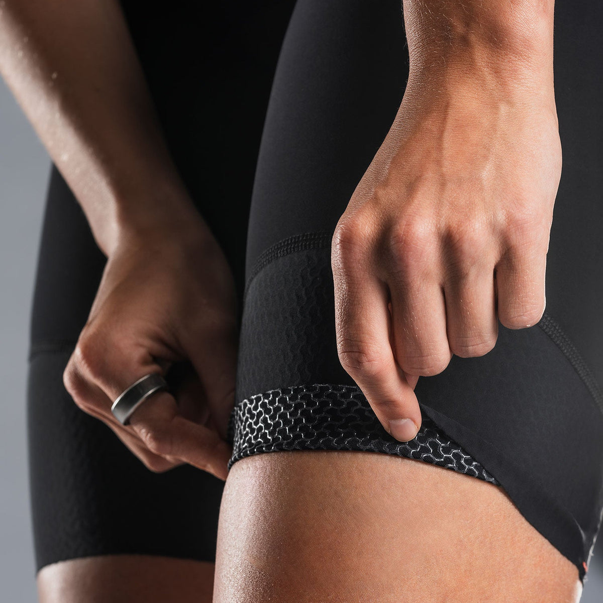 Close-up van zwarte fietsbroek, vingers tonen elastisch been-eindstuk