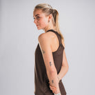 Vrouw in bruin trainingstop, van opzij en achteren zichtbaar